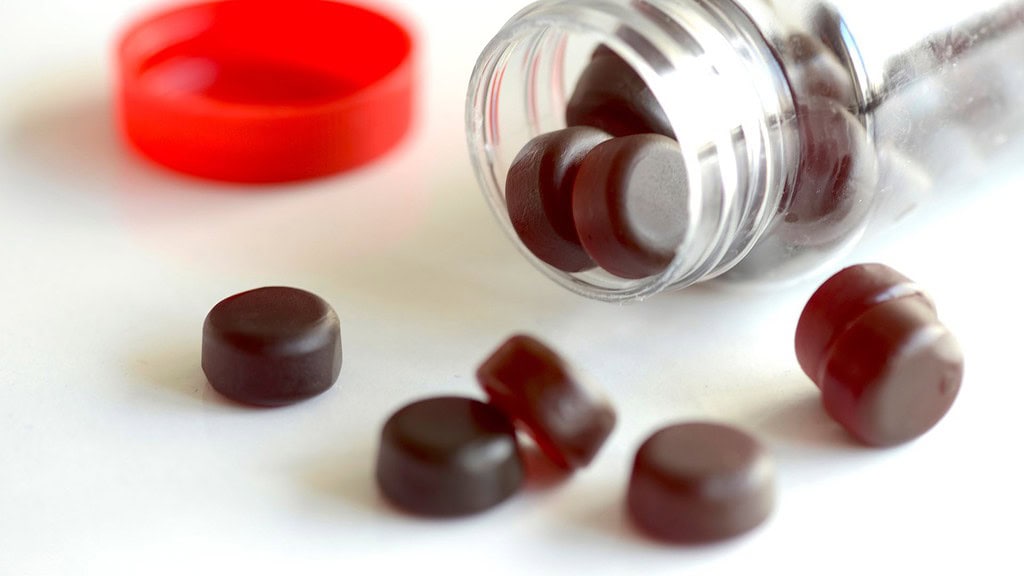 High-quality holistic herbal supplement pills spilled from a transparent container, highlighting natural health remedies and wellness products for optimal health benefits.