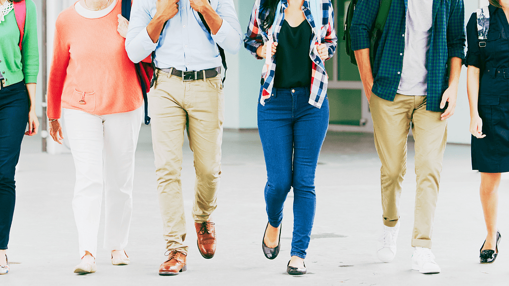 Wide-angle shot of a diverse group of young professionals walking together in a modern office environment, conveying teamwork, collaboration, and a professional yet relaxed atmosphere.